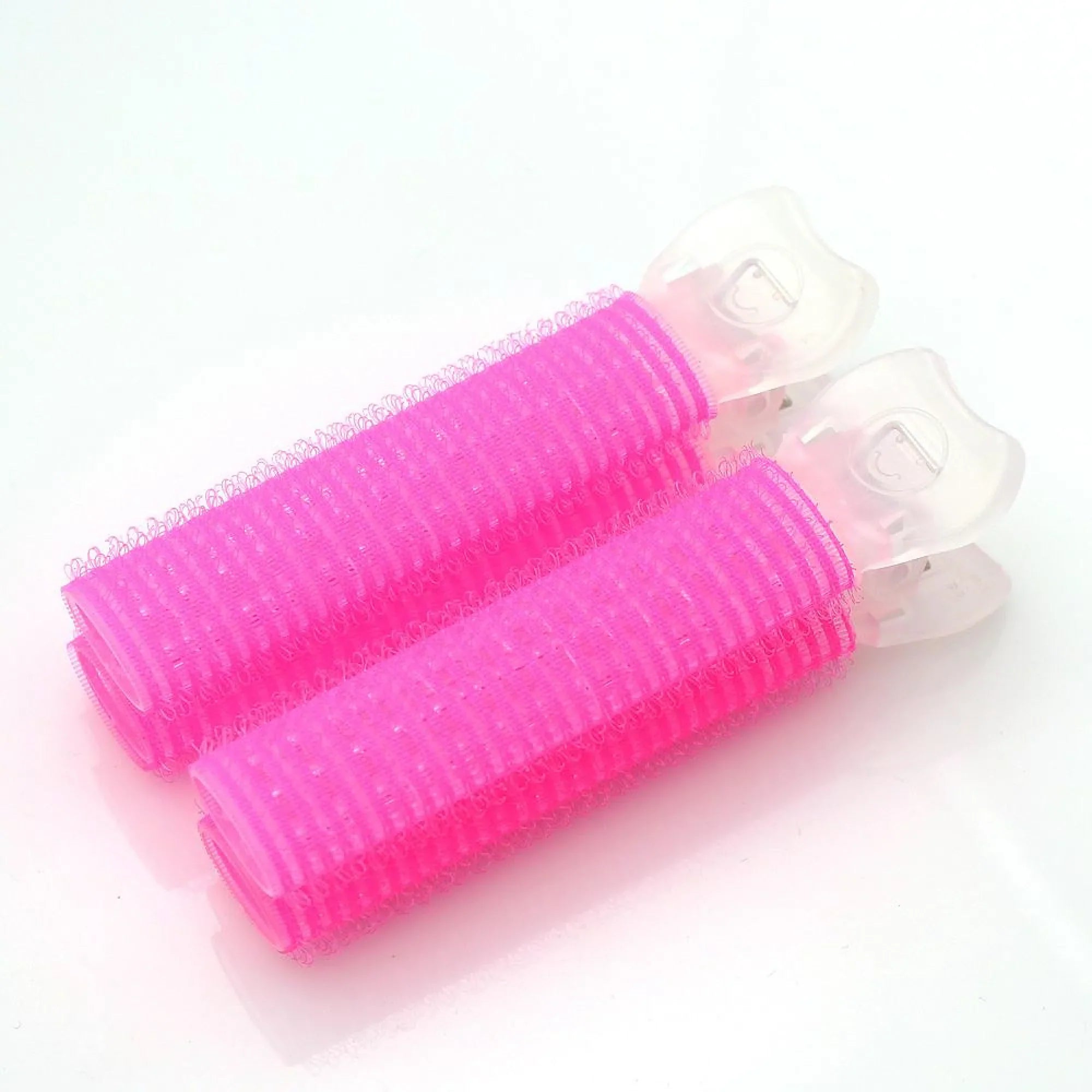Two pink hair rollers with clear plastic casings on a white background