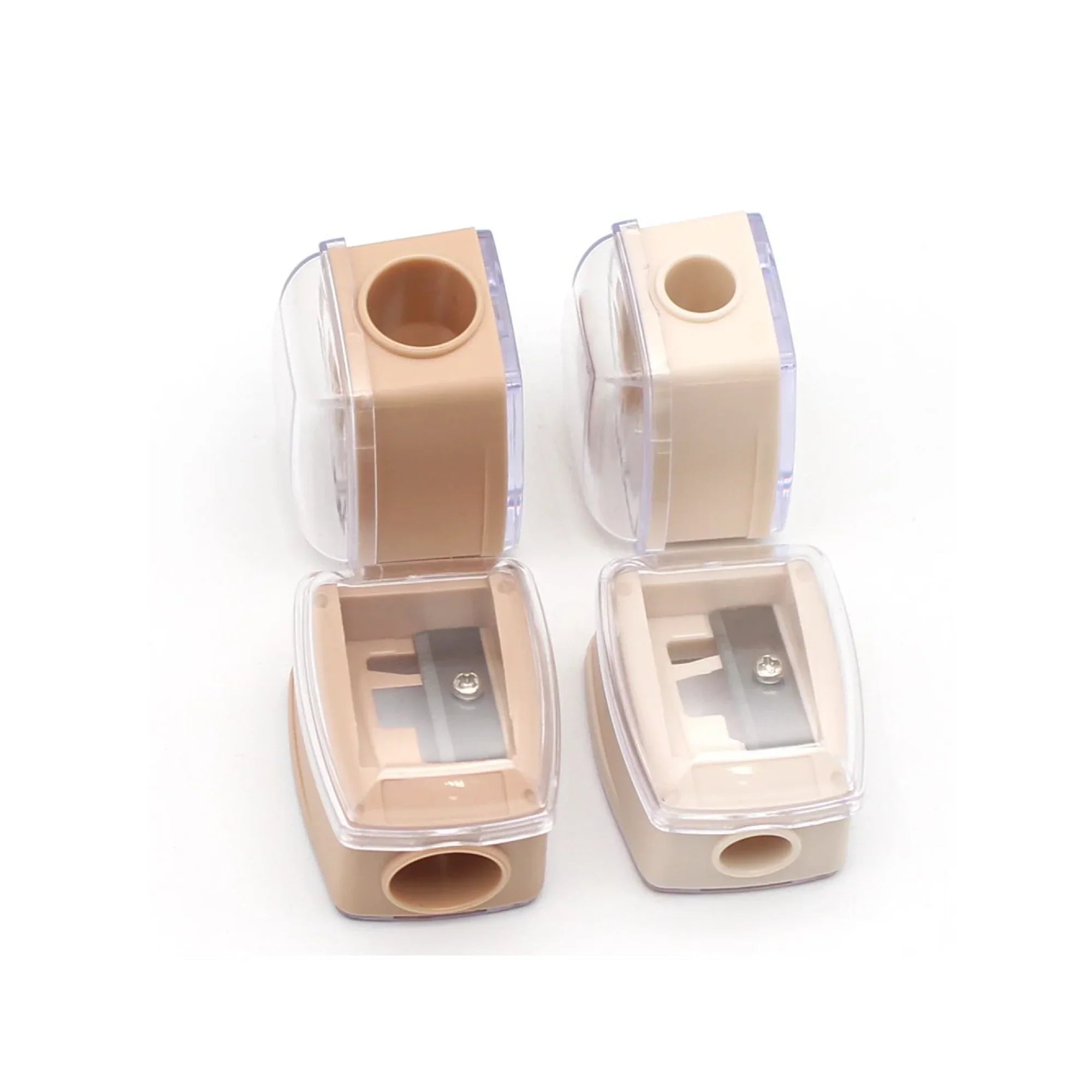 Four beige pencil sharpeners with clear tops on a white background